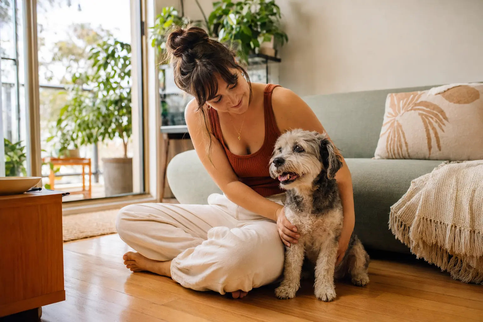 A young Australian dog owner relaxing with a small dog in a compact apartment